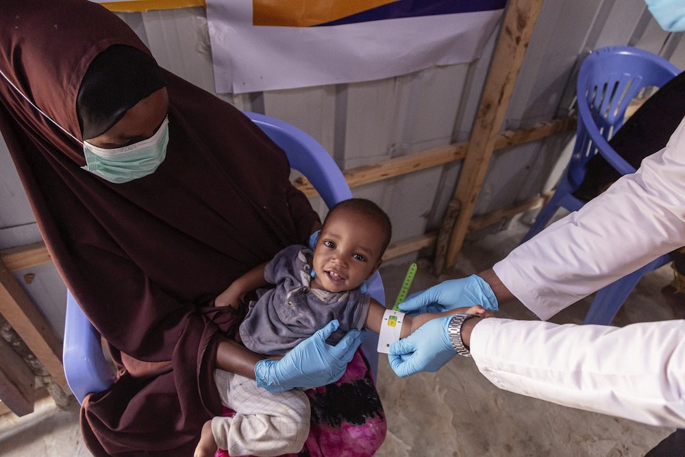 Amina's child receiving CMAM nutrition (a funded Innovation Fund project) support at IRC's health clinic in Somalia from the clinic nurse, Qadra. Amina and her seven children fled from their home in the Qoryooley region due to food insecurity.